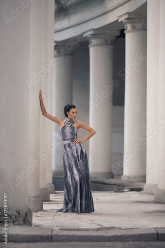 Foto young lady in dress at the entrance of neoclassical building