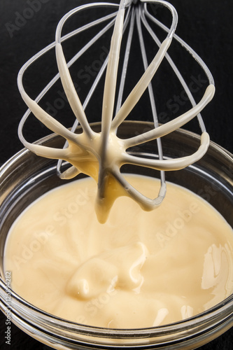 whisk and bowl with homemade custard