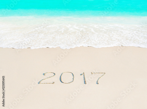 Year 2017 season concept on azure ocean tropical beach sand