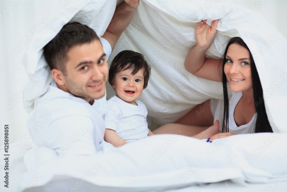 Attractive young family in the bedroom