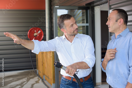 Man being trained to use fire extinguisher photo