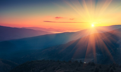 Fototapete Sonnenuntergang Panoramablick auf den farbenfrohen Sonnenaufgang in den Bergen. Gefiltertes Bild: Kreuz verarbeiteter Vintage-Effekt.  © vovik_mar