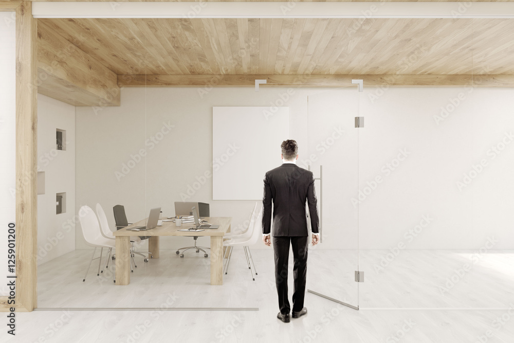 Man entering conference room with glass walls and doors Man entering conference room with glass walls and doors