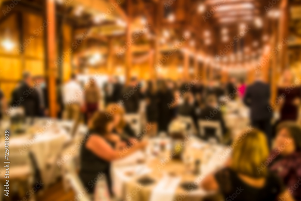 Defocused blur of wedding reception with guests dining and dancing