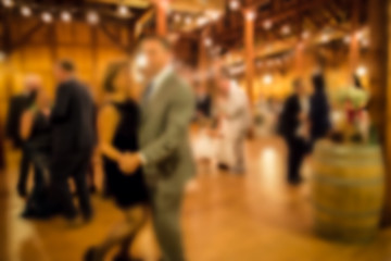 Defocused blur of wedding reception with guests dining and dancing