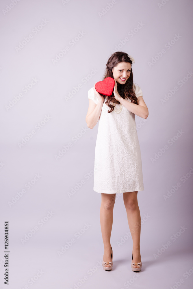 Redhead girl with gift for Valentines Day. Photo bokeh at background Redhead girl with gift for Valentines Day. Photo bokeh at background
