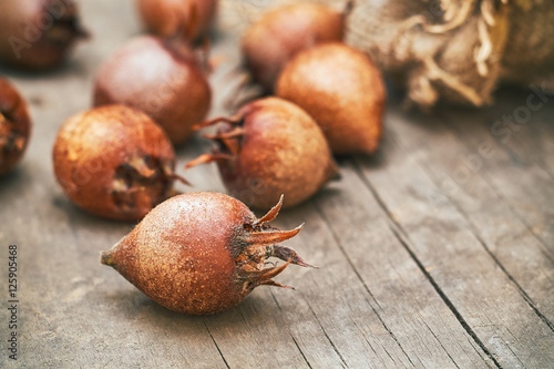 Common medlar fruit (mispel) on grey rustic wooden background. Copy space