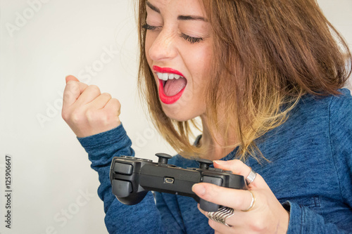 Close up of a young and caucasian girl with the joystick in hand, that wins game - people, lifestyle and moods concept
