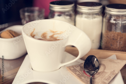 Cup of coffee latte art on geunge wooden background,retro filter photo