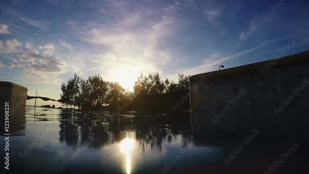 Surface of the outdoor swimming pool water in sunset Surface of the outdoor swimming pool water in sunset