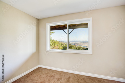 Empty room interior with brown carpet and light beige walls