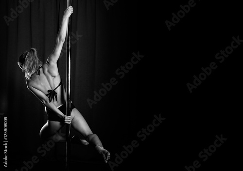 Foto Young woman dancing pole dance, woman on stick, beautiful girl in club, backgrou