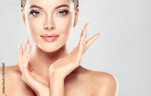Foto Schöne junge Frau mit sauberer frischer Haut berühren eigenes Gesicht