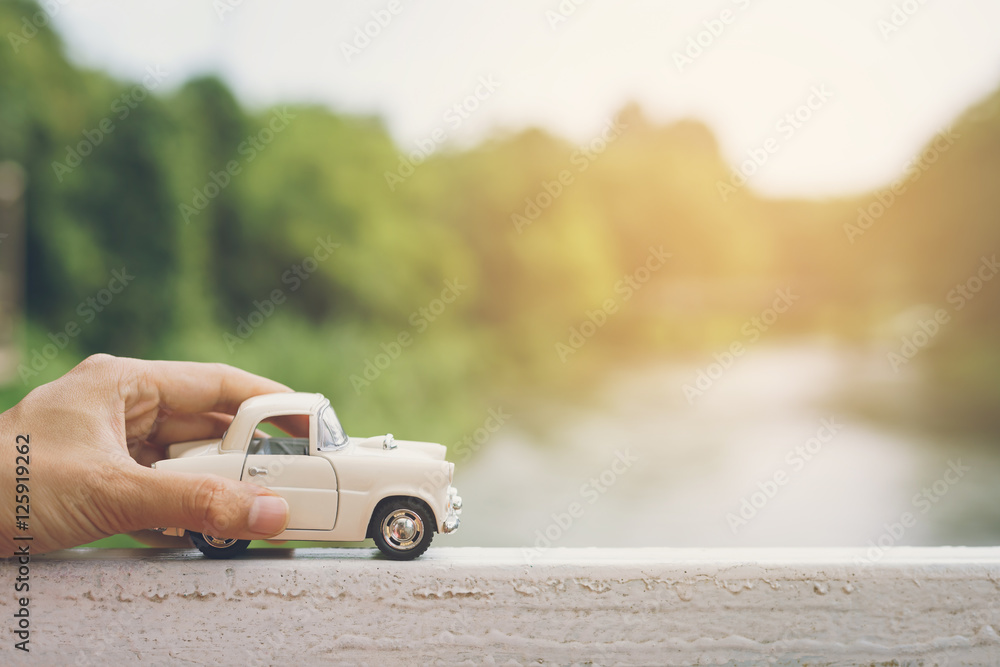 Obraz premium Hand holding a Car with landscape background