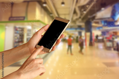 woman hand holding and touch screen of smartphone,tablet,cell phone over shopping center