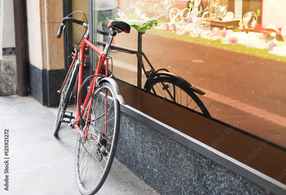 Bike leaning against shop window, downtown, europe environment -