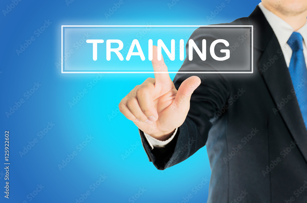 Business man is pushing TRAINING transparent button word over blue gradient background, business concept Business man is pushing TRAINING transparent button word over blue gradient background, business concept