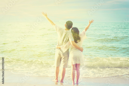 Vintage tone photo of Asian couple on beach with warm sun light