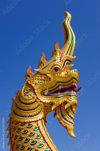 Naga statue head with blue sky background. © pecasusz