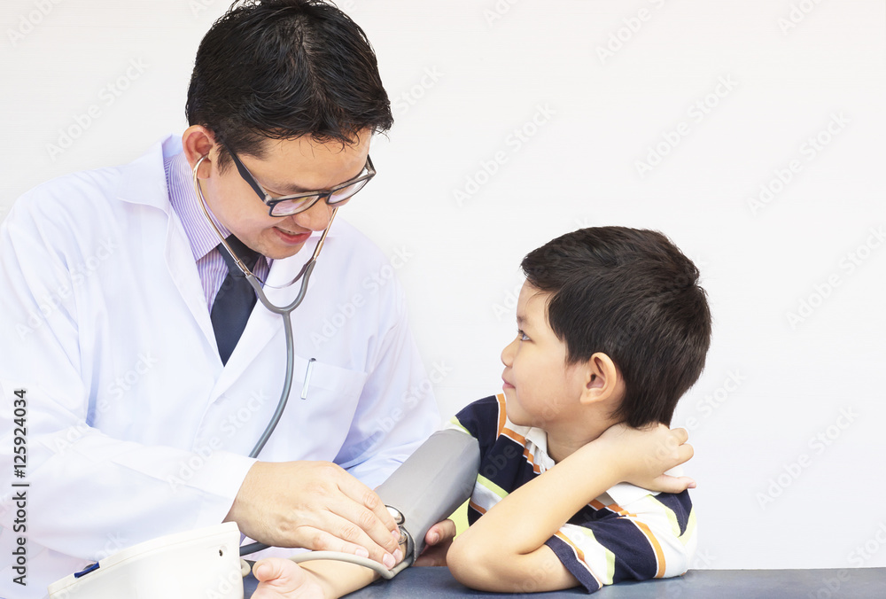 Asian boy being examined by male doctor using stethoscope and blood ...