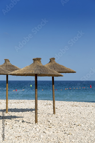 Fototapeta Naklejka Na Ścianę i Meble -  Parasols at the beach in front of blue ocean