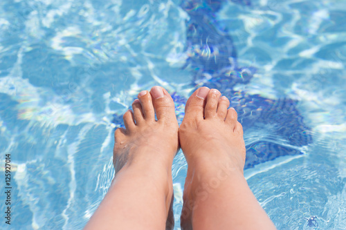 Woman feet on pool water