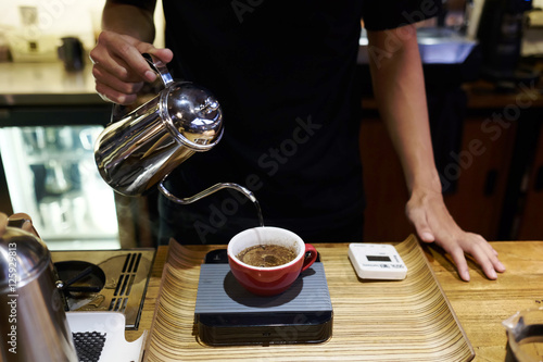 a man pouring coffee in the coffee shop