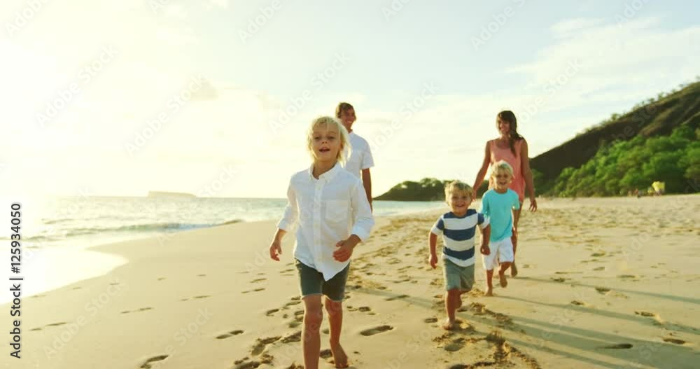 Happy family playing and having fun on the beach at sunset Happy family playing and having fun on the beach at sunset