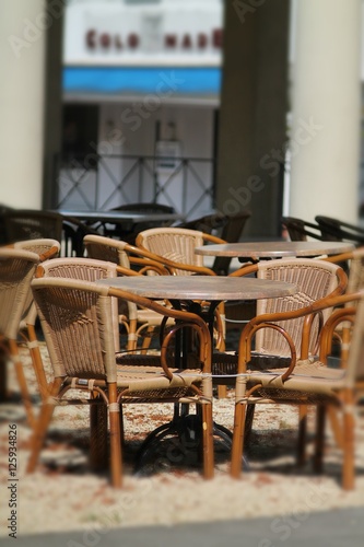 Foto Street cafe with brown  tables and cane chairs.