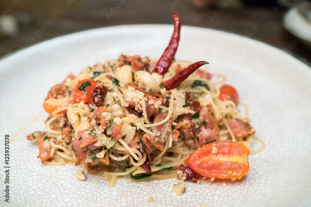 Spicy spaghetti with bacon and basil in the white dish.
Spicy spaghetti with bacon and basil in the white dish.
