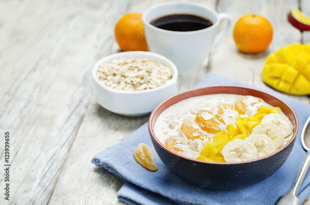 Oatmeal with mango, banana, tangerine oranges and coconut flakes Oatmeal with mango, banana, tangerine oranges and coconut flakes