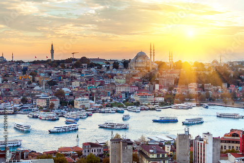 Tourist boat sails on the Golden Horn in Istanbul at sunset, Turkey. photo