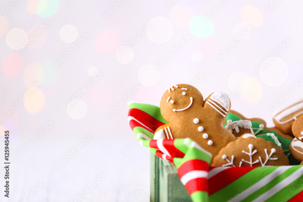 Obraz premium Box with tasty Christmas cookies on light background, close up view