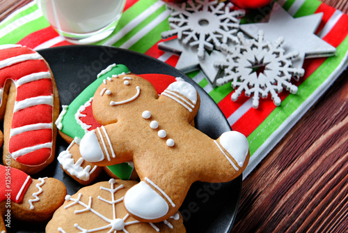 Plate with tasty cookies and Christmas decor on wooden table, close up view