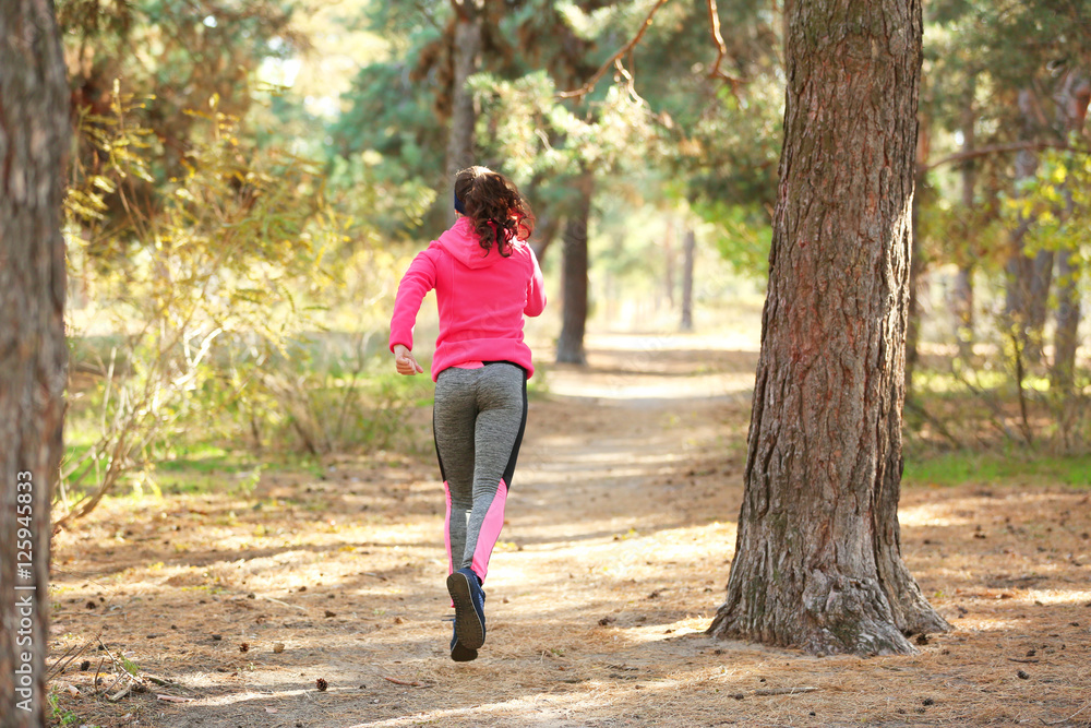 Sporty young woman running in autumn park Sporty young woman running in autumn park