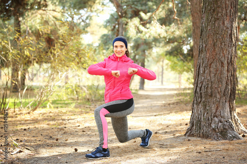 Sporty young woman training in autumn park