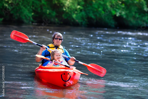 Father and child kayaking in summer