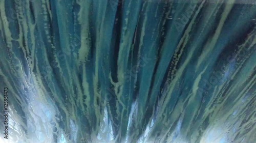 foam is running down the front window of a car in the car wash