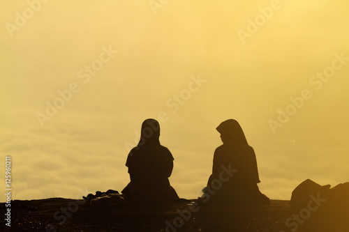 silhouette Romantic couple and sit and watch the sunrise on the