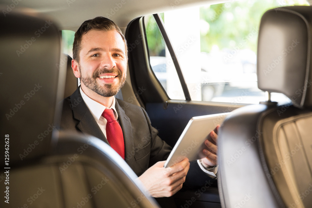 Businessman using tablet in a car