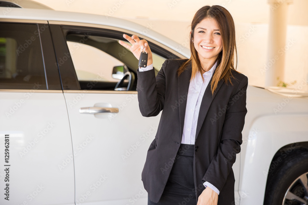 Young woman selling a car at the dealership