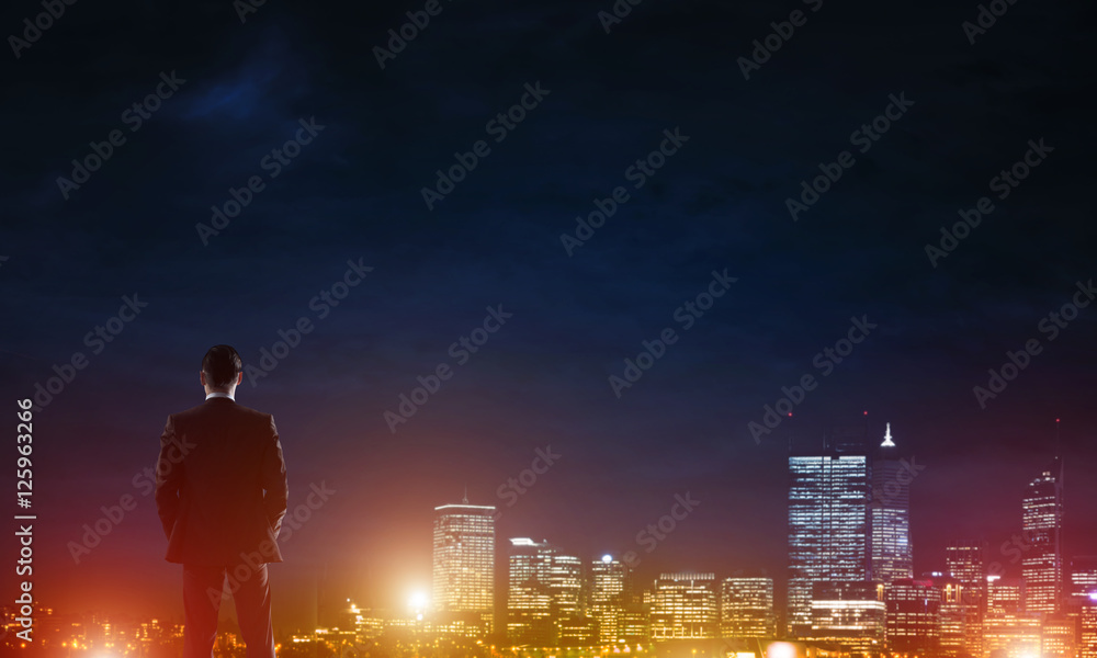 Businessman viewing night glowing city Businessman viewing night glowing city