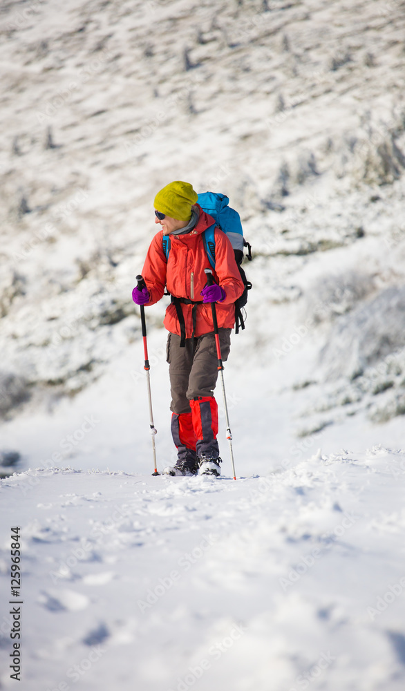 Girl with backpack walking on snow in the mountains. Girl with backpack walking on snow in the mountains.