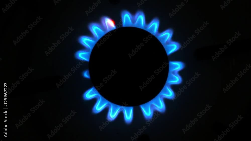 Burner gas stove close-up. Gas burns with a blue flame. Burner gas stove close-up. Gas burns with a blue flame.