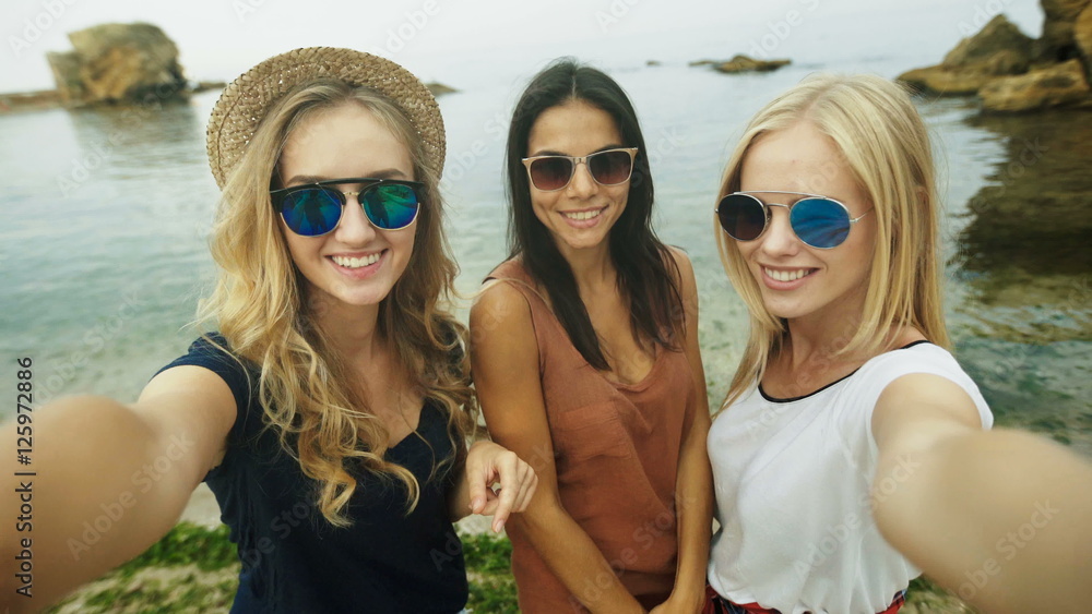 Three beautiful ladies taking selfies.