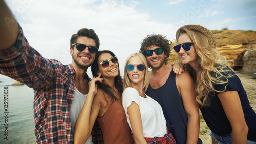 Five friends taking selfies .