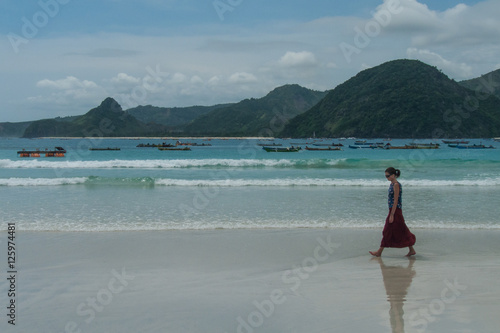 Femme marchant sur la plage de Selong Belanak, Lombok, Indonésie