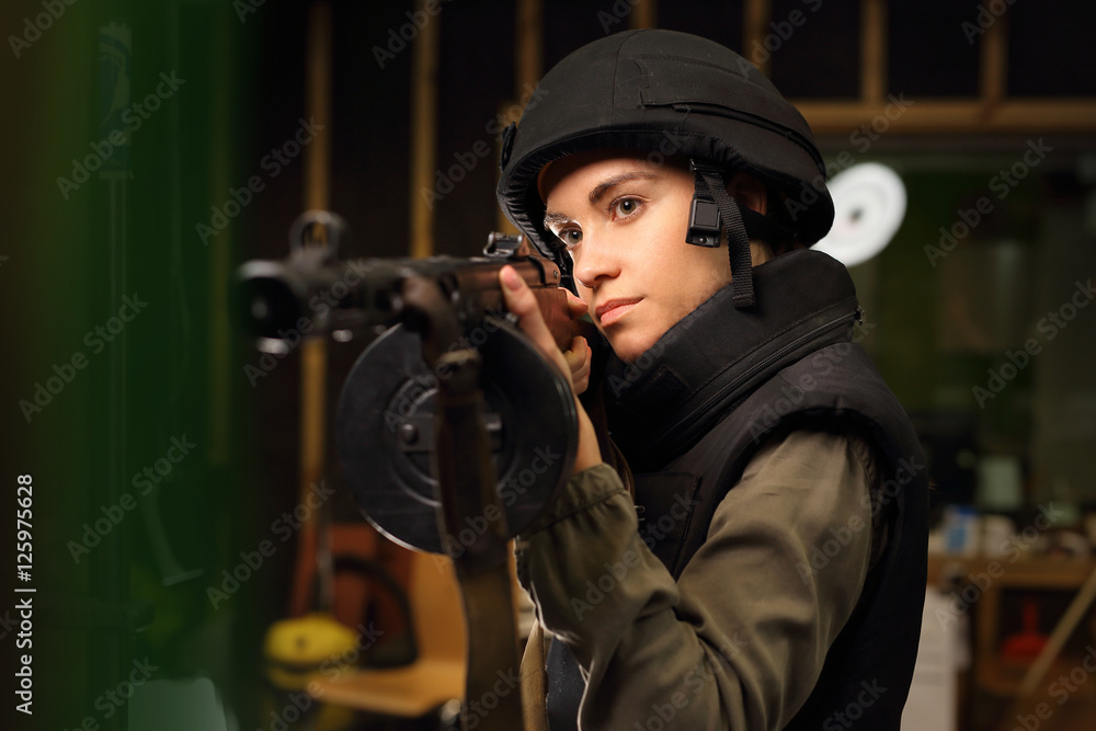 Fototapeta premium Karabin maszynowy. Kobieta strzela na strzelnicy