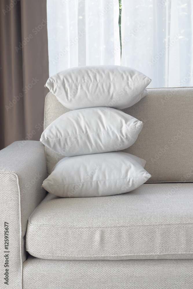 Stacking white pillows at the corner of sofa in living room Stacking white pillows at the corner of sofa in living room