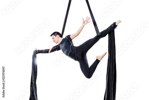 man hanging in aerial silk, isolated on white